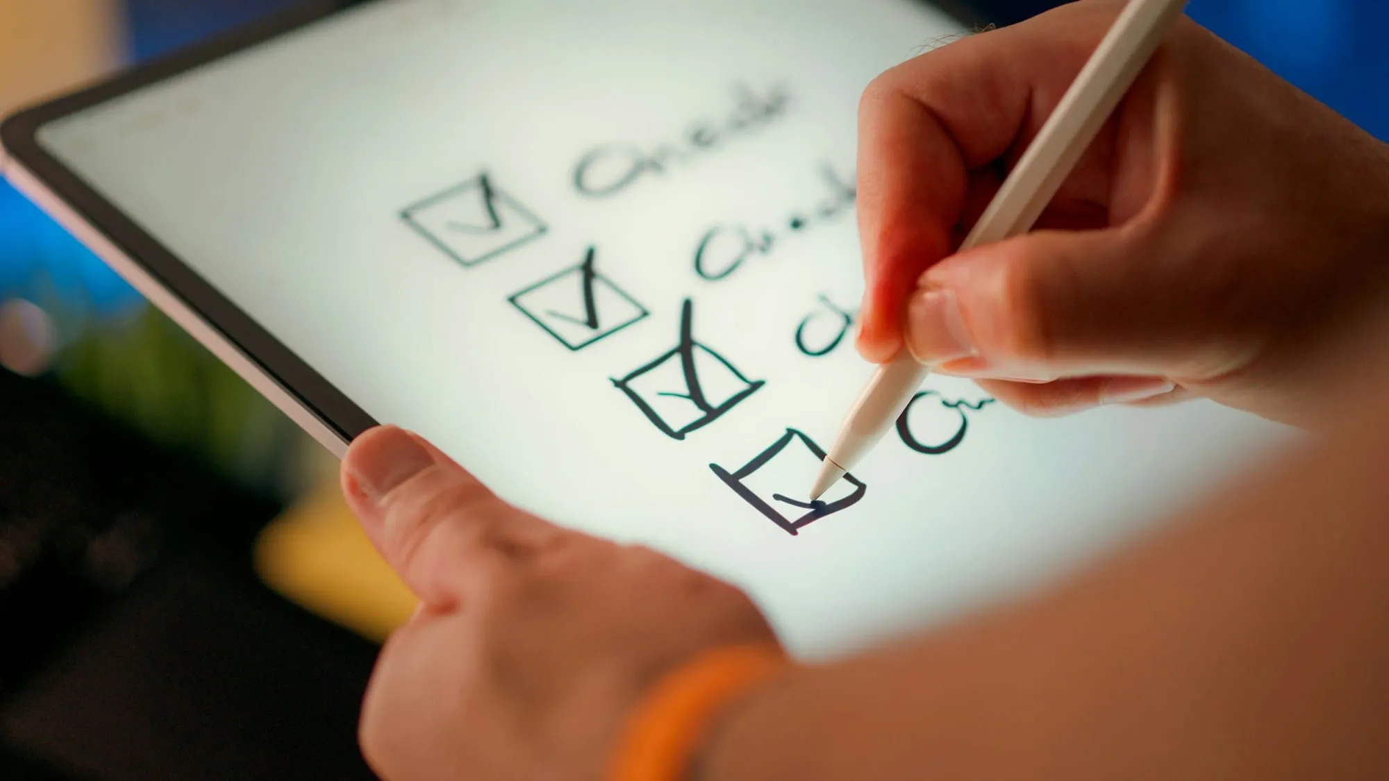 A hand ticking boxes on a checklist on a tablet